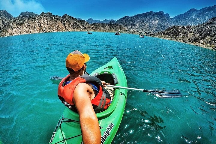 Experience the tranquility of Hatta's stunning lake surrounded by majestic mountains as you paddle through crystal-clear waters on your next adventure in the UAE.